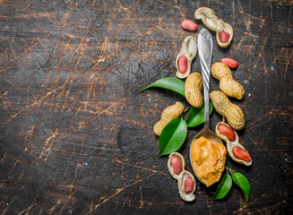 Wall Mural - Peanut butter in a spoon with leaves .