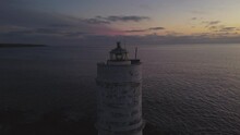 Establisher Shot Of Magical Solitary Lighthouse Shining Light At Dusk, Dolly Out