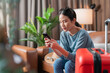 © whyframeshot - smiling asian female woman traveller hand using smartphone credit card checking booking flight ticket or hotel room reserving online through mobile application before taking abroad trip next vacation