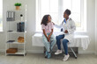 © Studio Romantic - Caring, understanding doctor touches shoulder of excited teenage girl who is worried before medical examination. African American girl is sitting on examination couch and talking to female doctor.