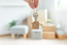 Moving House, Relocation. Woman Hold Key House Keychain In New Apartment. Move In New Home. Buy Or Rent Real Estate. Flat Tenancy, Leasehold Property, New Landlord, Dwelling, Loan, Mortgage..