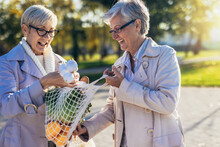 Happy Smiling Senior Female Friends Holding A Bags With Fruits And Vegetables Outdoor