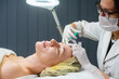 Leinwandbild Motiv Beautician apply skin injections in woman forehead