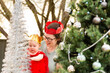© Austockphoto - Happy woman with baby experiencing Christmas wonder and tree sparkles at baby's first christmas