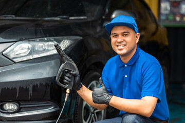 Wall Mural - Man worker washing car service. Car wash cleaning station high pressure water. Employees clean a vehicle professionally.