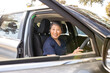 © Austockphoto - Nurse holding the car steering wheel and smiling at the camera