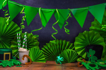 St. Patrick party invitation decorated background. Bar wooden table with various green decorations and accessories for a St. Patrick's Day party, copy space
