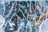 Fototapeta Desenie - An icy cracked transparent wall with decorative holiday decorations. Ice pattern and texture