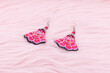 Chinese earrings, Close up of a pair of chinese style earrings on a pink background. Antique earrings for women.
