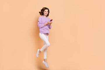 Wall Mural - Full length photo of adorable lovely lady wear purple trendy outfit bought use modern device empty space isolated on beige color background