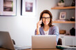 © sepy - Attractive middle aged businesswoman sitting at home and using cellphone and laptops