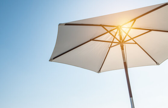 luxury umbrella in the sun against blue sky. hot summer relaxation and vacation concept.