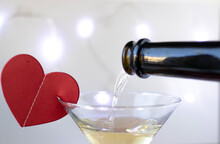 Paper Red Heart On Glass Edge With Champagne Drink Bottle Head Pouring Liquid Bokeh Light In Background.valentine Day Celebrate Love Drunk Couple Romantic Date