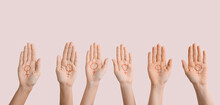 Many Female Hands With Drawn Symbols Of Woman On Their Palms Against Light Background. Concept Of Feminism