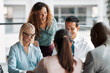 © Flamingo Images - Smiling businesspeople working together around a table