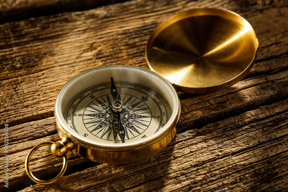 Vintage compass on wooden surface