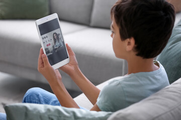 Canvas Print - Little boy video chatting with psychologist at home, closeup