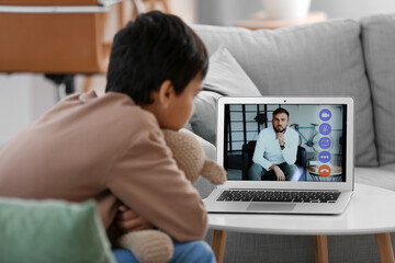 Wall Mural - Little boy video chatting with psychologist at home, closeup