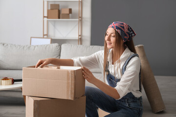 Wall Mural - Young woman with cardboard boxes in living room on moving day