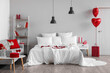 © Pixel-Shot - Interior of light bedroom decorated for Valentine's Day with sofa and shelving unit