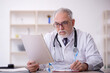 © Elnur - Old male doctor working in the clinic