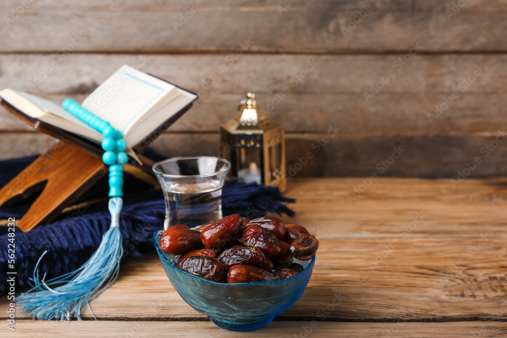 Bowl with dried dates for Ramadan on wooden table, closeup