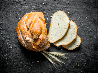 Wall Mural - Sliced wheat flour bread with spikelets.