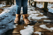 Child Walking On Snowy Trail In Wet Winter Boots