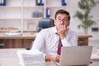 © Elnur - Young male employee and too much work at workplace