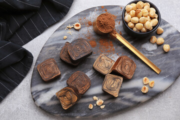 Flat lay composition with tasty chocolate candies and nuts on light grey table