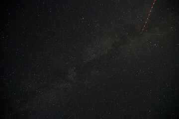 Wall Mural - Satellite trail passing through the milky way, night-sky