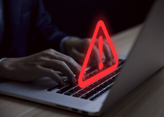 Wall Mural - businessman using laptop showing warning triangle and exclamation sign icon warning of dangerous pro