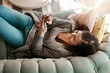 © Reese/peopleimages.com - Woman relax on sofa with phone, social media scroll and communication at home, contact and technology. Happy woman, smile for meme and web search with streaming, smartphone and rest on couch top view
