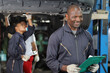 © feeling lucky - Group of car mechanic in uniform checking maintenance a lifted car service with clipboard at repair garage station. Worker holding wrench and fixing breakdown vehicle. Car repair service concept