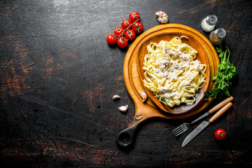 Sticker - Pasta fettuccine with Carbonara sauce on a plate and tomatoes with spices.