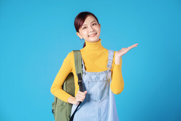 Poster - Young Asian student posing on blue background