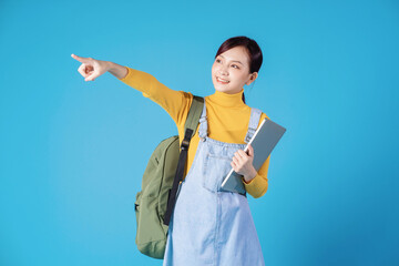 Poster - Young Asian student posing on blue background