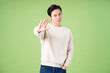 Portrait of young Asian man posing on green background
