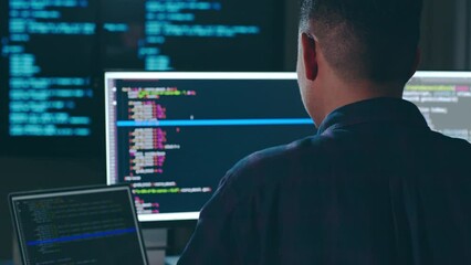 Young Asian man, developer programmer, software engineer, IT support, working hard at night overtime on computer to check coding in bugging system