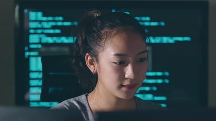 Young Asian woman, developer programmer, software engineer, IT support, working hard at night overtime on computer to check coding in bugging system and running program successful.