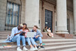 © yurolaitsalbert - students with a laptop and a digital tablet sitting on the steps.