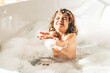 © Mariia Korneeva - Little girl in bath playing with foam.