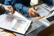 © Wasan - The meeting brainstorming discusses business audits and analyzes the market statistical charts of startups and financial planning advisors.