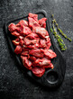 © Artem Shadrin - Sliced raw beef on a black cutting Board with thyme.