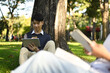© Prathankarnpap - Smiling asian male students using tablet, preparing for exam while under tree in campus. Education and lifestyle concept
