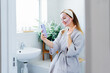 © okrasiuk - Smiling woman with facial pink clay mask taking selfie with mobile phone at home bath enjoying relaxation and spa beauty treatment. Teen Beauty blogger creating content. Selective focus, copy space.