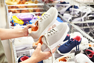 Sticker - Woman chooses sports shoes in clothing store