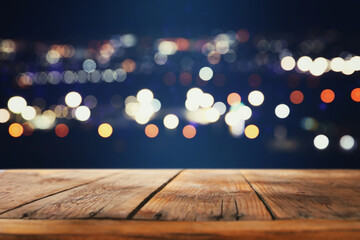 Wall Mural - background Image of wooden table in front of abstract blurred street lights