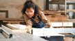 © Nassorn - Portrait, female multiracial carpenter working in woodshop small business. Afro woman with goggles standing in DIY carpentry workshop with confidence. Empowerment joiner women in woodworking industry