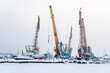 © Cavan Images - Boats moored at snow covered harbor against sky